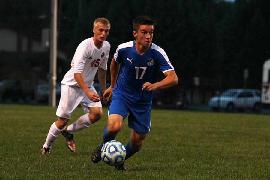 Daniel Picioski (12) sprints down the field, with his opponent trailing behind. Picioski planned to keep his focus on school, not soccer, during college.
