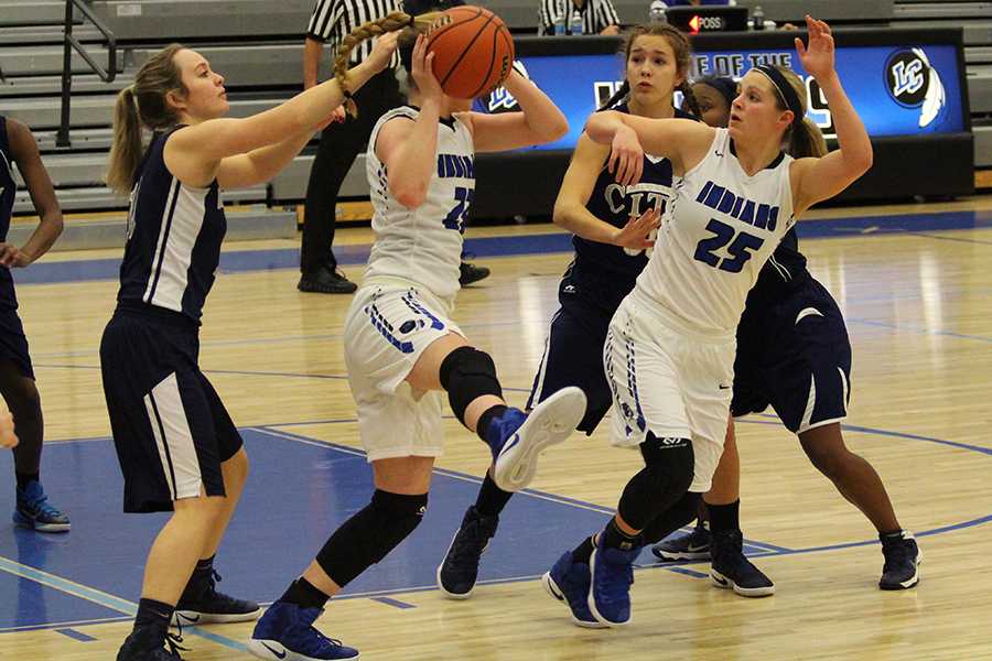 Bailey Fehrman (10) and Meghan Long (10) try to get the ball away from the opposing team. The final score was 57-17.

