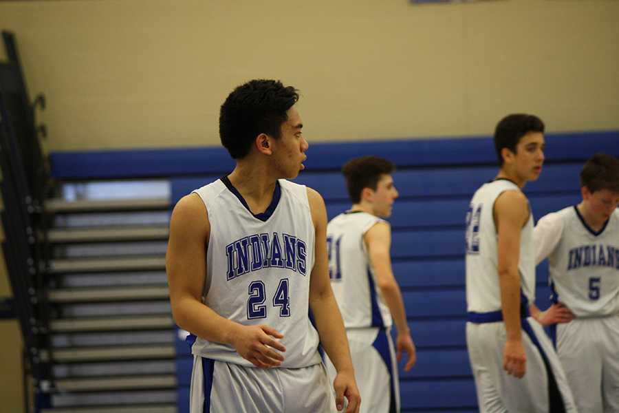 Ethan Ramos (9) looks back as the opposing team shoots a free throw. The Indians rebounded the ball and continued to play their offense against the Cardinals.
