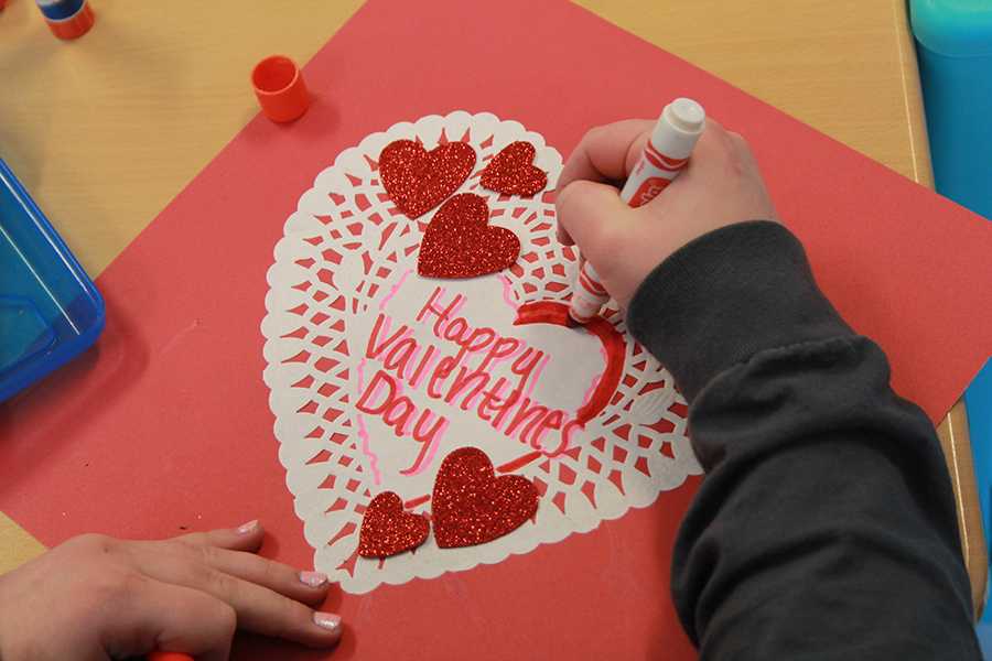 Kaitlyn Kennedy (10) works on decorating the card for Valentine’s Day. Kennedy decorated the cards with her friends in the club.