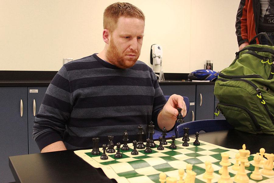 Dr. Dustin Verpooten, Science, moves his black knight into position. Verpooten has been the sponsor of the Chess Club for five years.