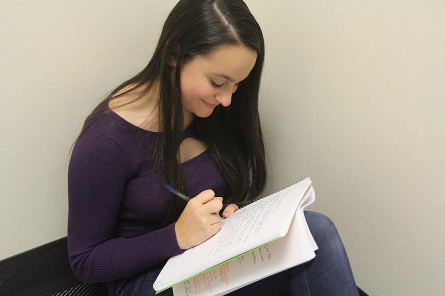Emily Gaines (10) writes in her notebook. She has been working on her story “Are You Afraid of the Dark?” for over two years.