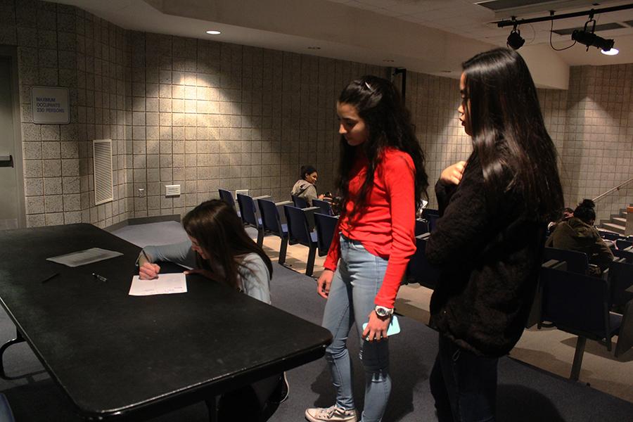 Allison Centanni (9), Veronica Gonzalez (9) and Charmagne Abangan (9) signing their names on the sign in sheet before the meeting starts. Every meeting they have to sign in to show you commitment to the club.