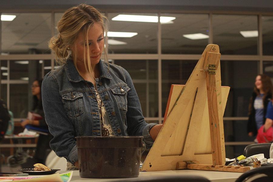 Kayla Martin (11) paints a sunflower onto a canvas. Throughout the night, fine arts students showcased their talents and abilities for all attendants to see. 