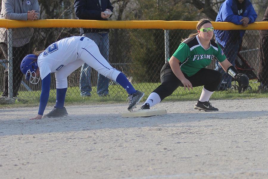 Hanna Hullinger (9) falls as she hits third base. The team has been undefeated since the start of the season. 
