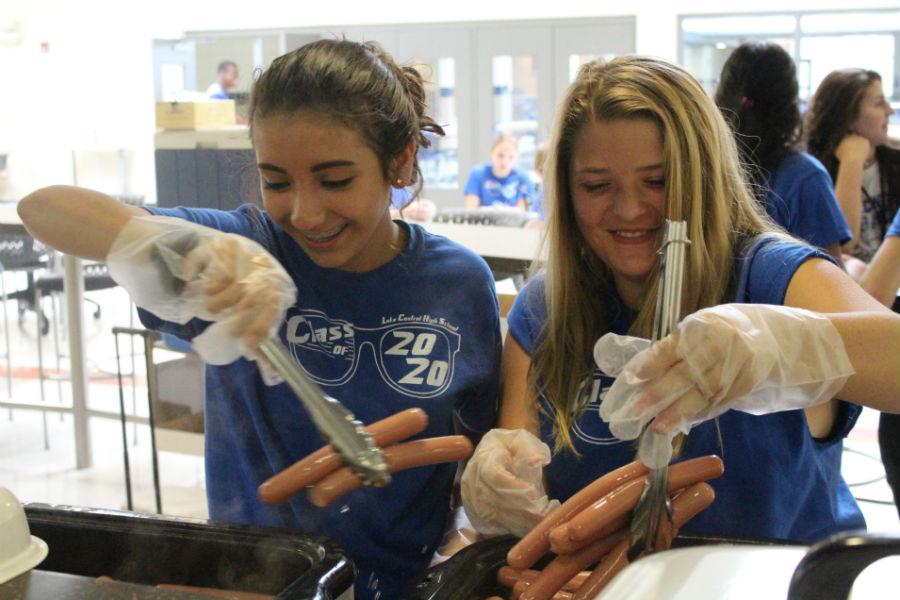 Frida Arellano (10) and Jade Mehock (10) prepare hot dogs for lunch. Arellano and Mehock were volunteers at the rush.