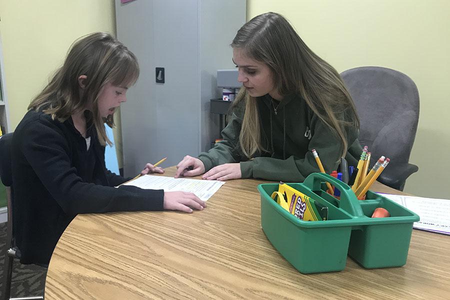 Erin Plenus (12) helps a child she is tutoring with reading. She has helped with tutoring for three years. 