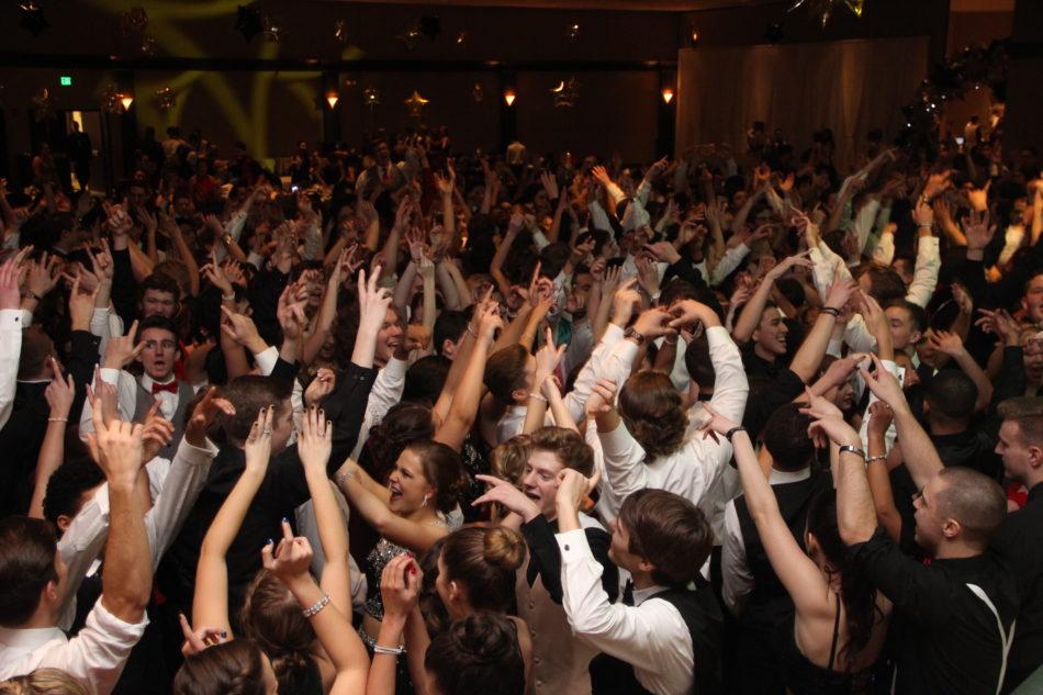 Students raise their hands during the Winter Formal dance. The formal dance for the 2017-2018 school year was Jan. 20. Photo by Justin Andrews 

