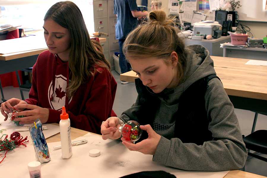 ey Imming (10) and Paige Covelli (9) finish decorating their ornaments. The activity of the meeting was to make and decorate Christmas ornaments.
