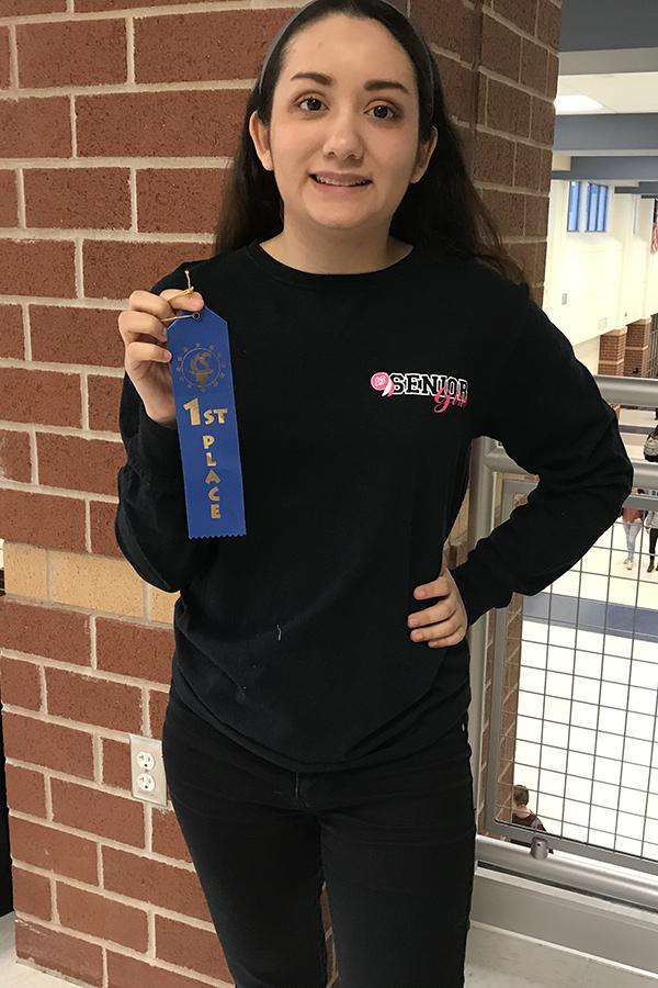Caroline Chavez (12) holds a first place ribbon received at the Lowell Invitational. The Fine Arts team studied music and art from World War I.  