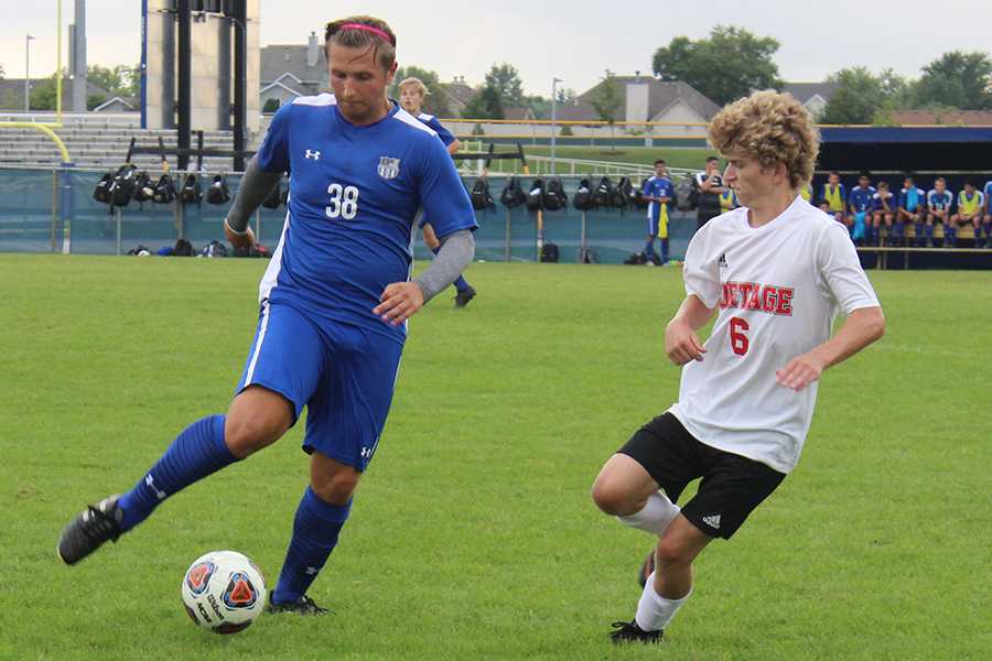  Derek Baldin (10) moves the ball down the field. A Portage player attempted to steal the ball from Baldin, but to no avail.