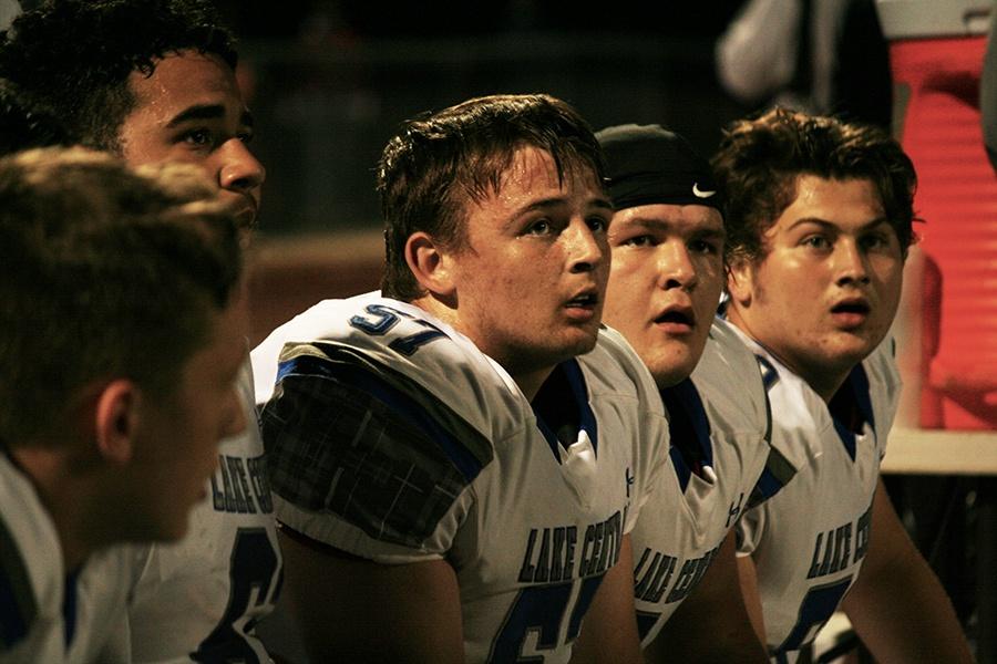 Mitchell Johnston (12) sits on the bench next to some of his teammates during the tough game against the Crown Point Bulldogs.   The team cheered each other on in support from the sideline.