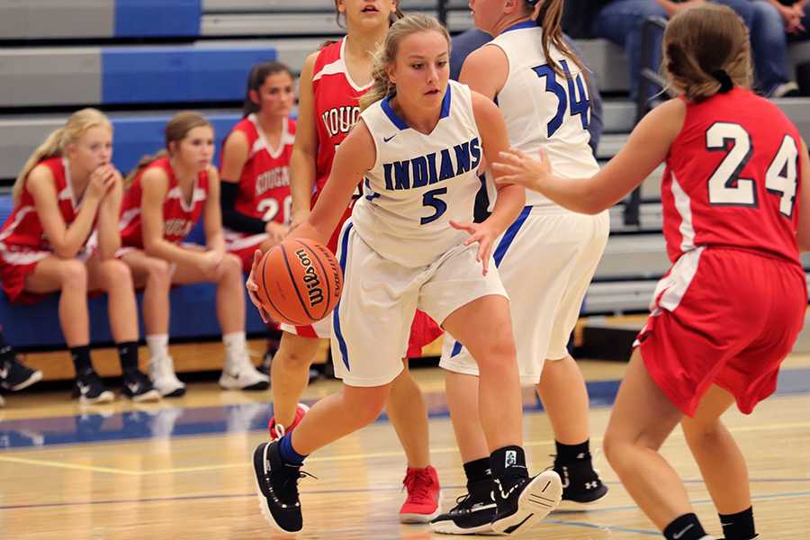 Brittani Koons (9) dribbles the ball to the basket.  She had to face the other team to get there.