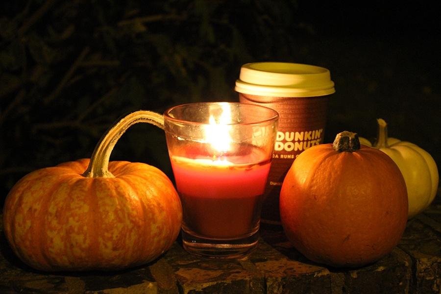 A pumpkin, coffee and candle are shown. October is known as Spooky Season.