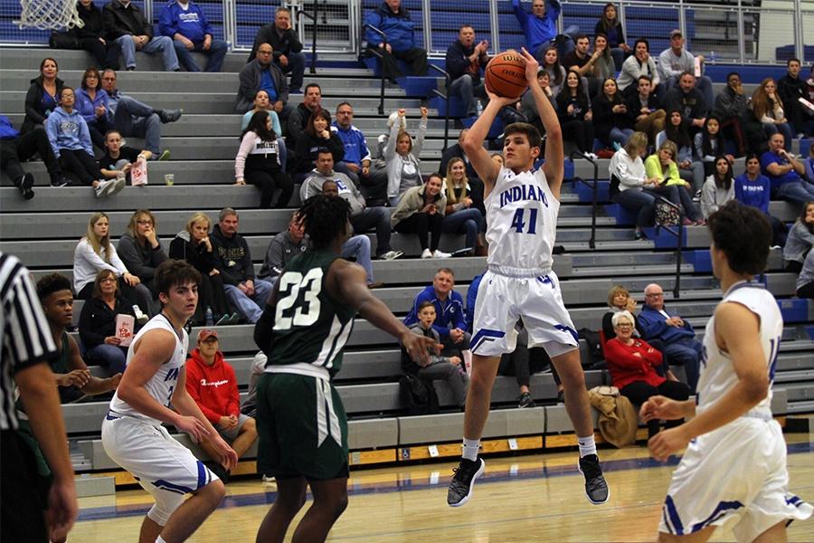 Hunter Zezovski (11) jumps in an attempt to score a point. Zezovski played as a front guard for the team.