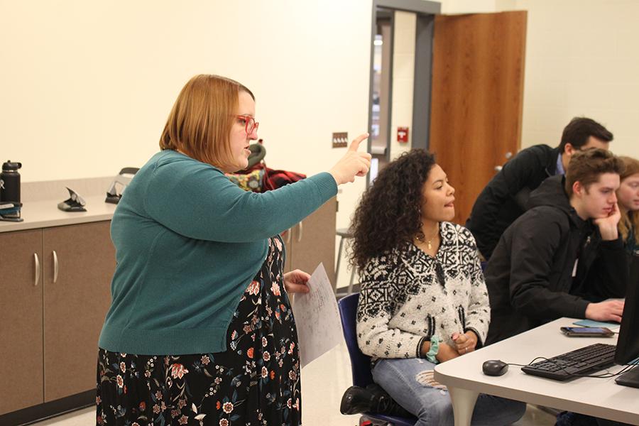 Ms. Allison Peda, English, explains to Bianca Matchain (12) what to do for creating the pins. Peda was the teacher sponsor for the club.