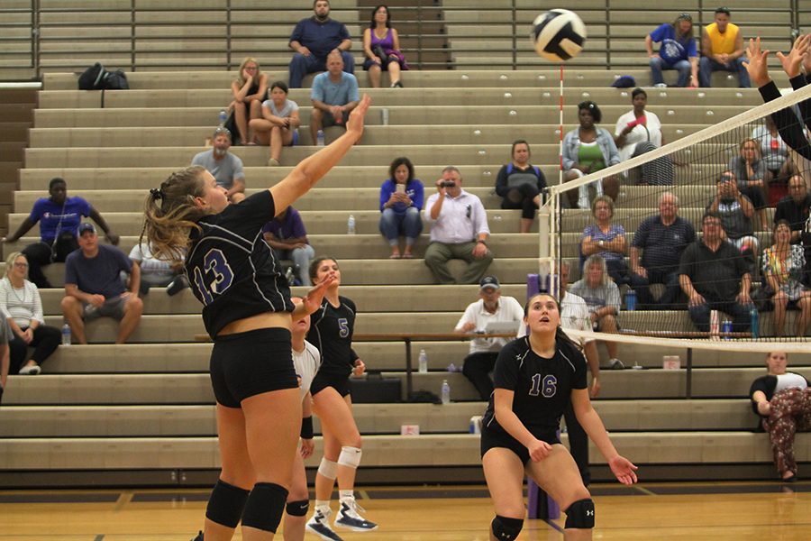 	Katia Nikolic (9) serves the ball over the net during the 1st set of the match creating a bigger lead for the Varsity team. Her confidence and determination helped guide the ball over the net throughout the game.