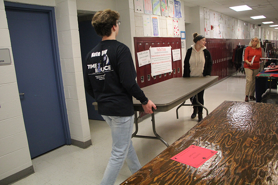 Nathanial Grahovac (12) and Emma Robustelli (11) assist a woman by carrying a heavy table to the opposite end of the school. Many vendors thanked the volunteers for the work they provided.
