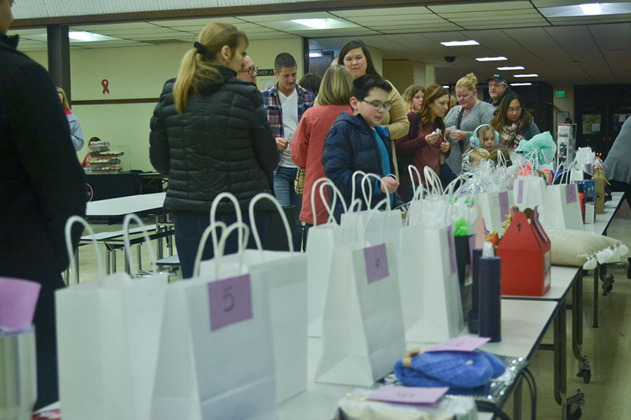 Students and families place a raffle ticket in various bags. Companies like Zig-E’s Funland and Starbucks donated items and vouchers for the raffles.