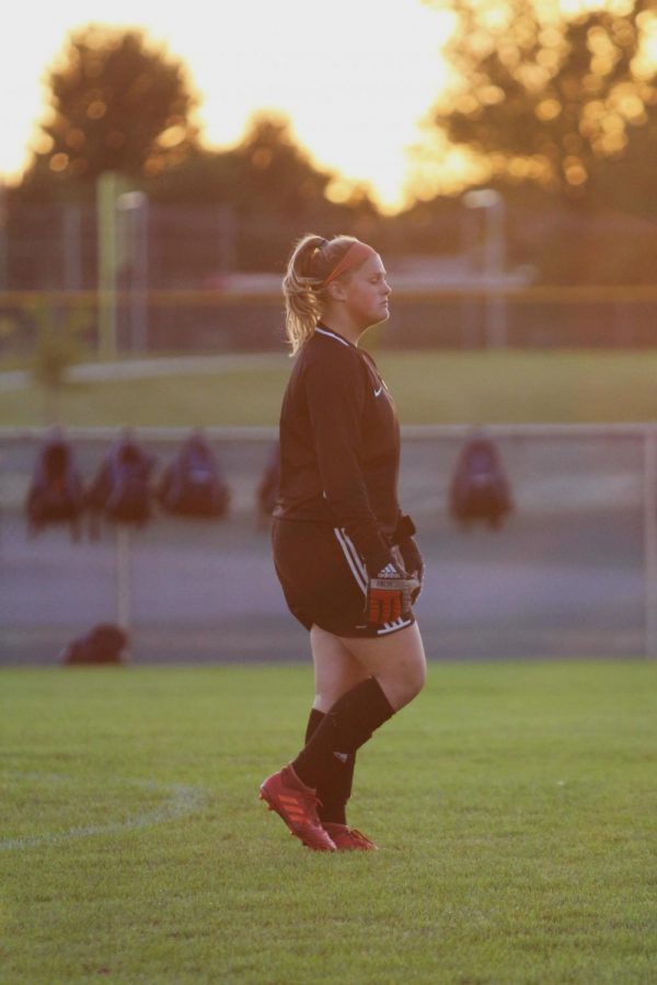 Tatum Damron (11) watches the players anticipating their next move in the first game of the season against Crown Point.  Her determination and skills quickly showed on the field as she protected the net and her team.  