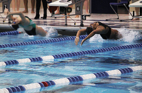 Jourie Wilson (10) goes up against a Valparaiso swimmer as she pushes off to start her race. She was swimming backstroke.