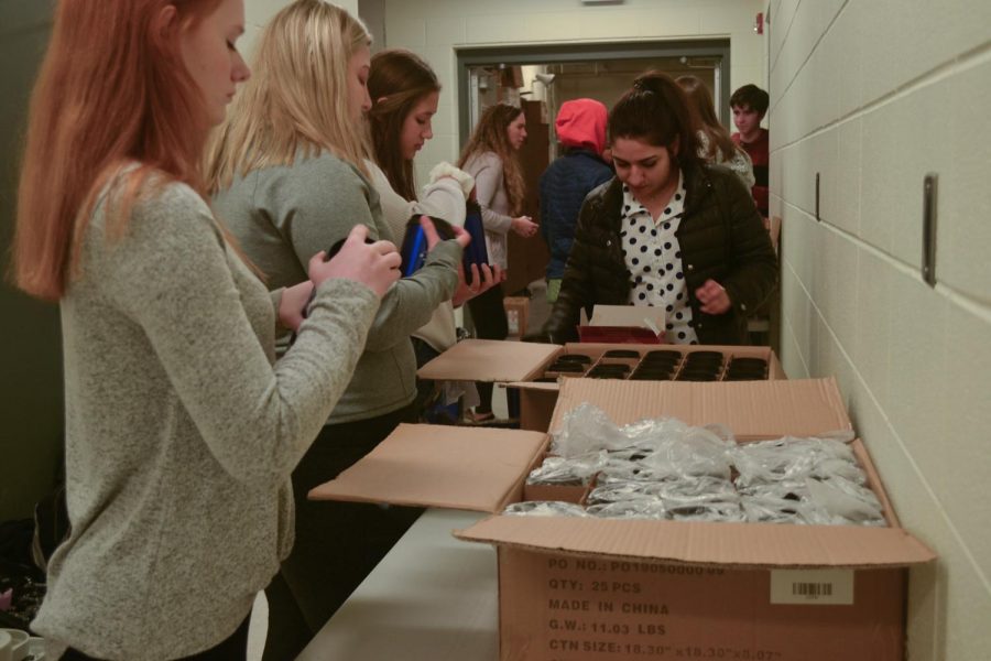  The students concentrate on packing the mugs. To make the process faster, the students worked in groups and created assembly lines at multiple tables.