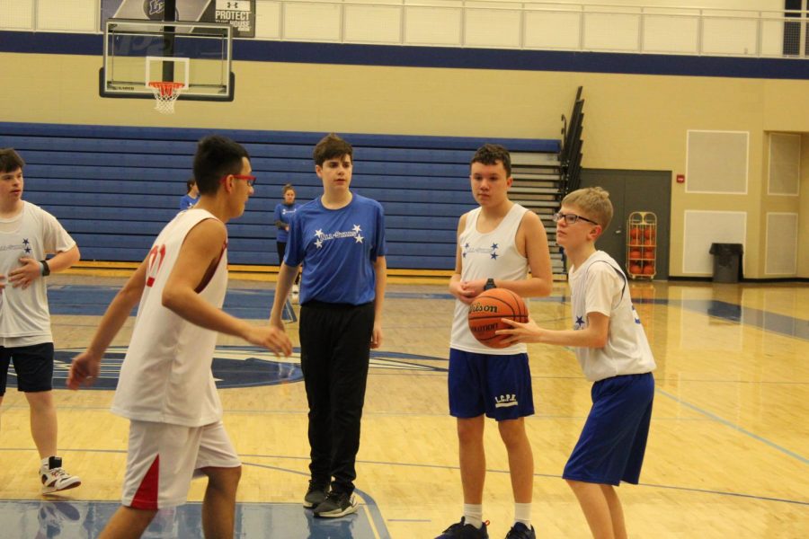 The All-Star starts to get ready to shoot the ball while someone is guarding him. People were cheering on them while he was trying to make his shot. 