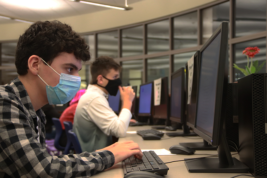 Students sit in the computer lab working on assignments for class. They all have to wear masks in order to follow social distancing guidelines. 