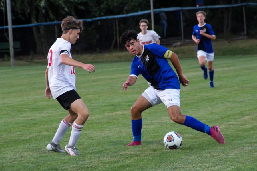 Emilio Zambrano (12) kicks the ball away from a Portage player. Zambrano is one of the three seniors on the team this year.