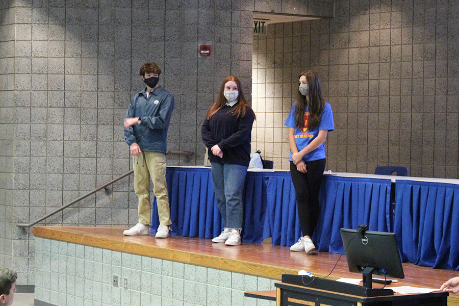 Luke Hamilton (12), Hailey Prasopoulos (12) and Marissa Haberling (10) listen to Ava Orueta (12) while she gives a speech. They were there to help answer questions at the end of the meeting.