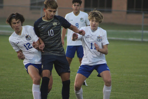 Miller Knestrict(9) and Jake Noldin (11) fight for the ball against a Bishop Noll player. The Indians won this game with a score of 4-3. Photo taken by Tiffanie Richerme.