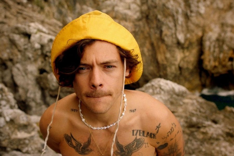Harry Styles crouches in front of the camera with a mustache and pearls. Styles released a music video to his hit single “Golden” on Oct. 26. It reached over 9 million views and 1.8 million likes in 8 hours of its release.