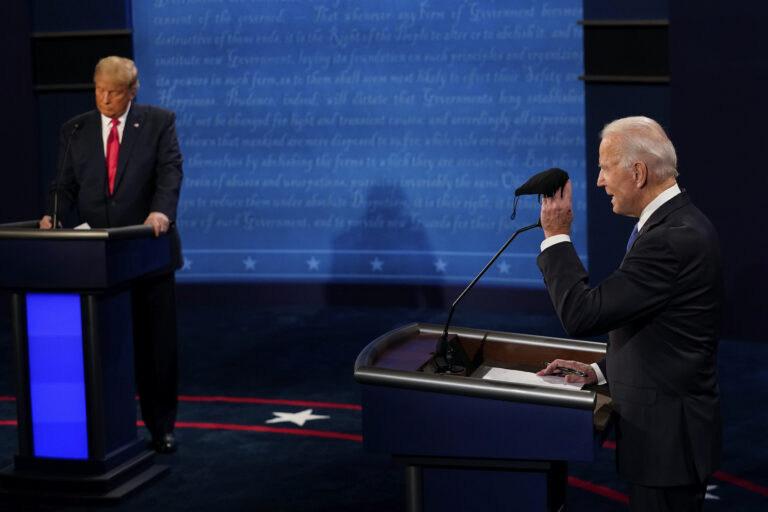 Democratic presidential candidate former Vice President Joe Biden holds up a mask as President Donald Trump takes notes during the second and final presidential debate Thursday, Oct. 22, 2020, at Belmont University in Nashville, Tenn. (AP Photo/Morry Gash, Pool)