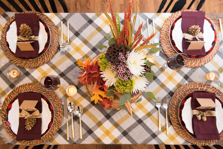 Thanksgiving table gets dressed up with fancy plates and festive decorations. Families might have to limit the amount of members at their table.