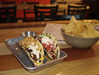  Ricochet Taco is a modern fusion restaurant that has unique tacos. The Filthy Animal taco (left) and True Romance taco (right) are two of the signature tacos on the menu.