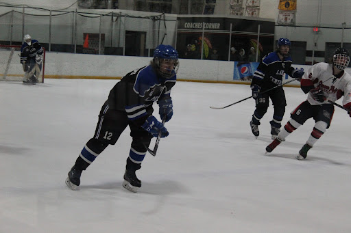 Gliding towards the puck is Jayden Lazowski (12). He was moving with his team towards the opposing team’s goal.