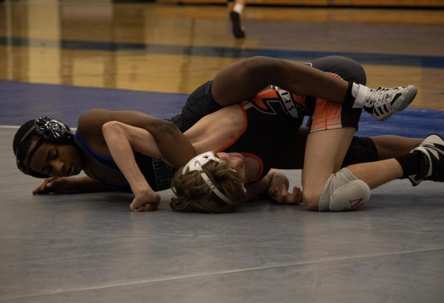 Mason Jones (10) takes over his control in his match, grabbing onto his competition. Jones manages to take him down by stretching him out with a half nelson.