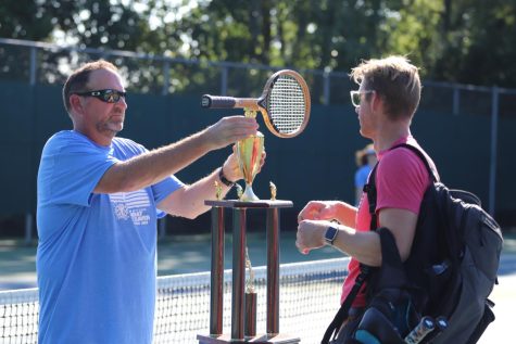 Coach Holden (Athletics) grips the Old Wooden Racket trophy in front of Lowell’s coach.  LC’s team went on to win back this trophy for the fourth year in a row.