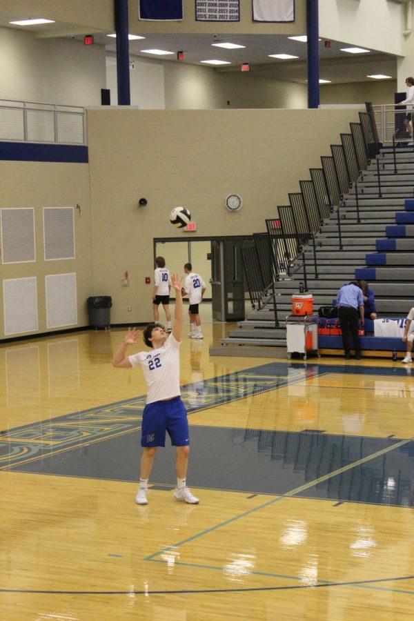 Serving the ball, Christian Czarnik (9) stands behind the line. He got the ball over to the net to start the volley during one of the JV games.