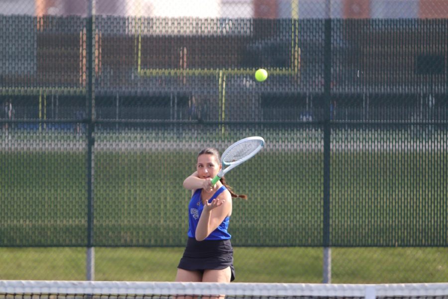 Hitting the ball, Elise Smith (12) sends the ball back across to her opponent. She had set herself up at a good angle so she could have a forehand to return the serve.