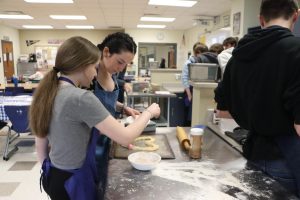 Natalee Stevenson (9) and Brayden Cooper (10) sprinkle sugar on the heart. It was made out of leftover pizza dough, making an additional dessert.