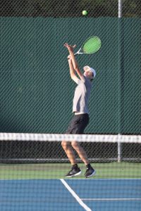 In order to help his teammate during the doubles match, Trevor Bembry (12), jumps in the air to keep the ball from landing on their side. The ball went back and forth until it finally earned Bembry a point. 