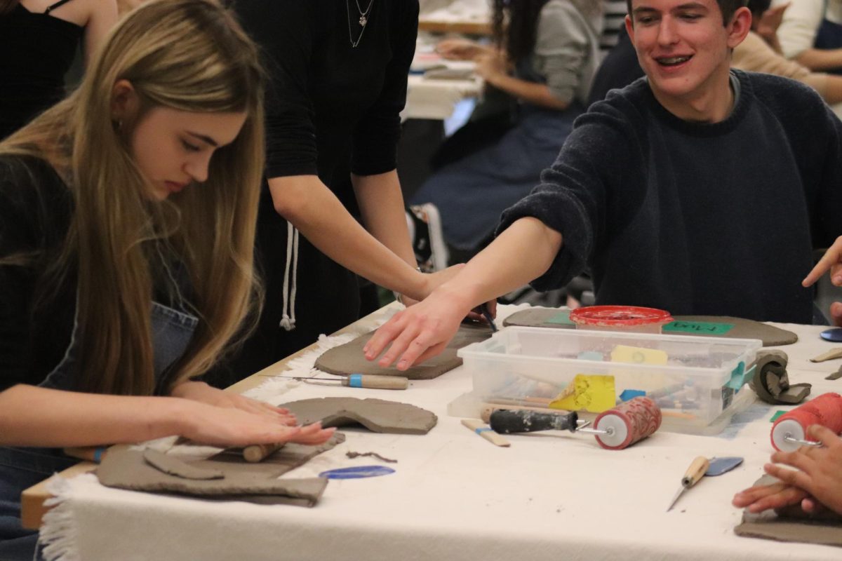 With great focus, Morgan Maas (11) rolls a design into a slab of clay at the art club meeting on October 18. She used this textured clay to make a cup. 

