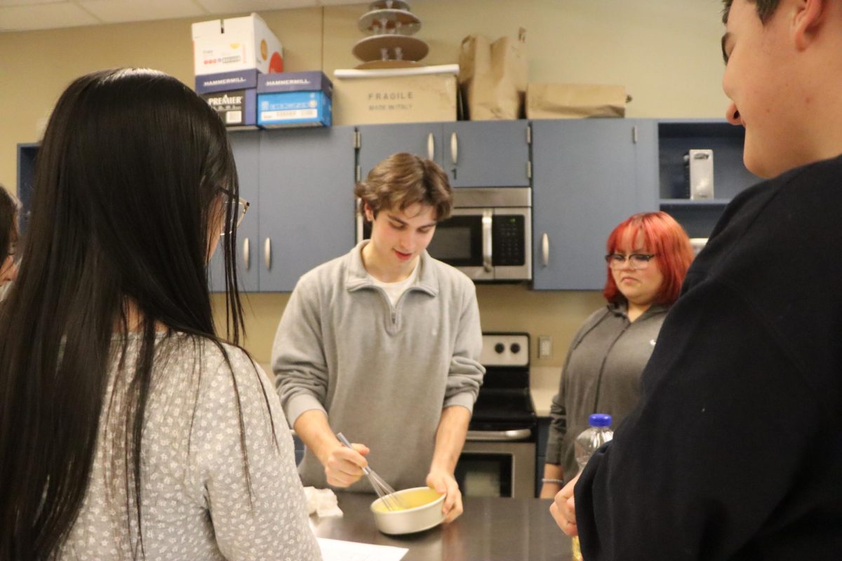 Starting off his groups dish, Nicholas Piunti (10) whisks eggs together as everyone else watches. The eggs were the foundation of the meal which added protein for the students to eat.
