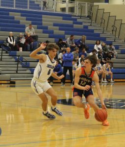 Keeping his opponent away from the net,  Cooper Kroncke (10) successfully guards his opponent from the Raiders. Although they put up a tough fight, Lake Central lost.