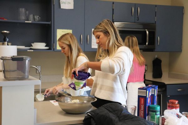 Tilting the bag, Kennedy Graham (11) measures out the mozzarella into a measuring cup while her group members work on cleaning the dishes and cooking the beef. Their hard work won’t go unnoticed by the family that enjoys their meal.