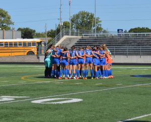 Before the game starts, the girls varsity soccer team huddles up for a quick pep talk. The girls talked about their plans for the game before they faced the opposing team.