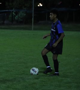 Warming up, Ruperto Gomez (12) works on his foot skills. During his warm up time, Gomez practiced dribbling around defenders. 