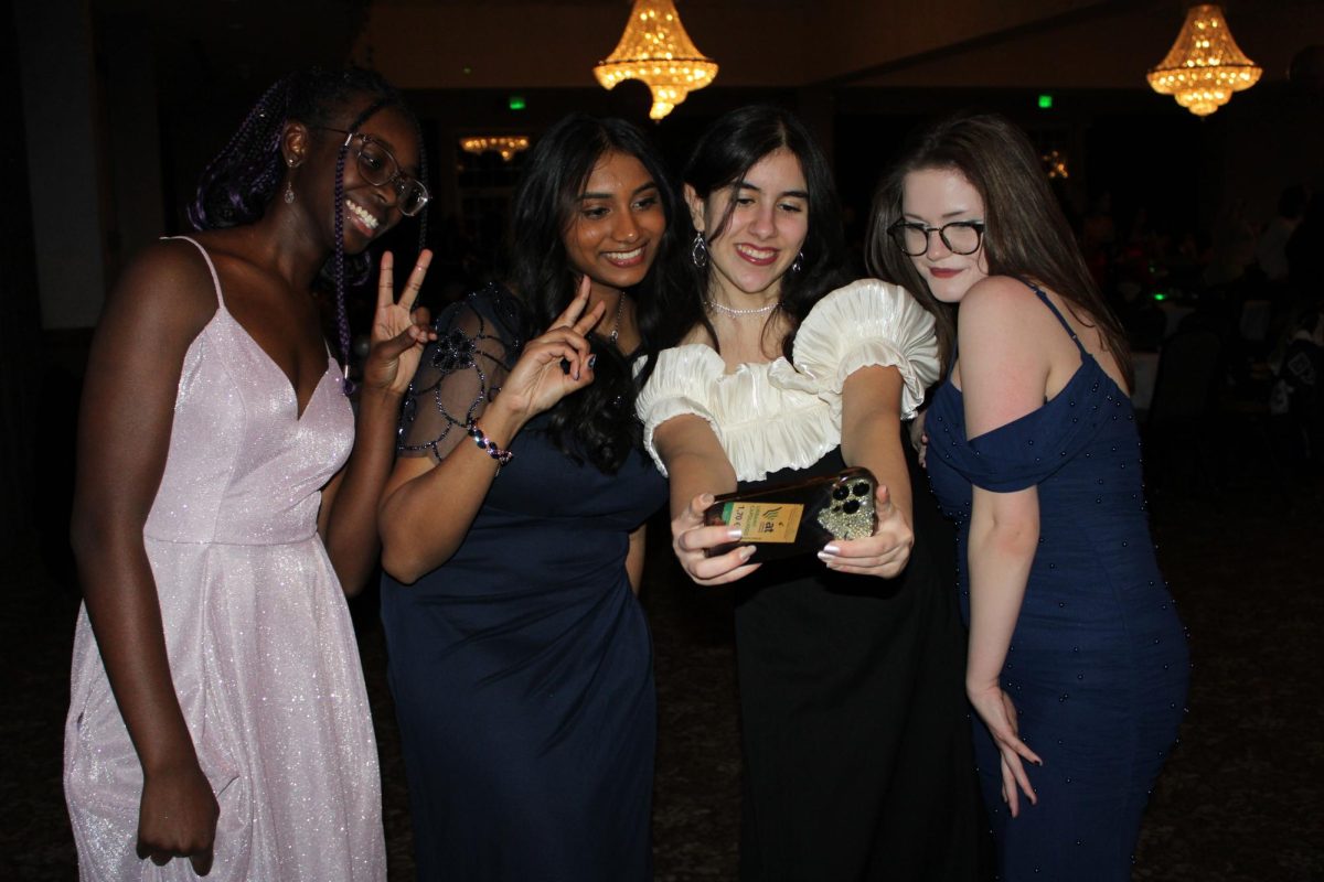 While taking a break from dancing, a group of friends pose for a photo near the refreshments. At the dance, water, lemonade, fruit punch and tea were served. “I went formal because it is my junior year, and I’ve never been before. I can’t wait to go again next year,” Tia Abughofah (11) said. 