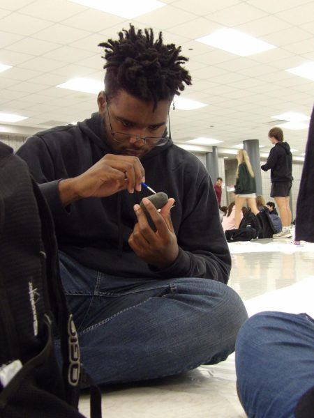 Gliding his brush across the rock, Anthony Greer (11) shapes his vision. Greer was working with his friend and is getting feedback on his work. “I like this because it gives me an opportunity to use my art skills,” Greer said.